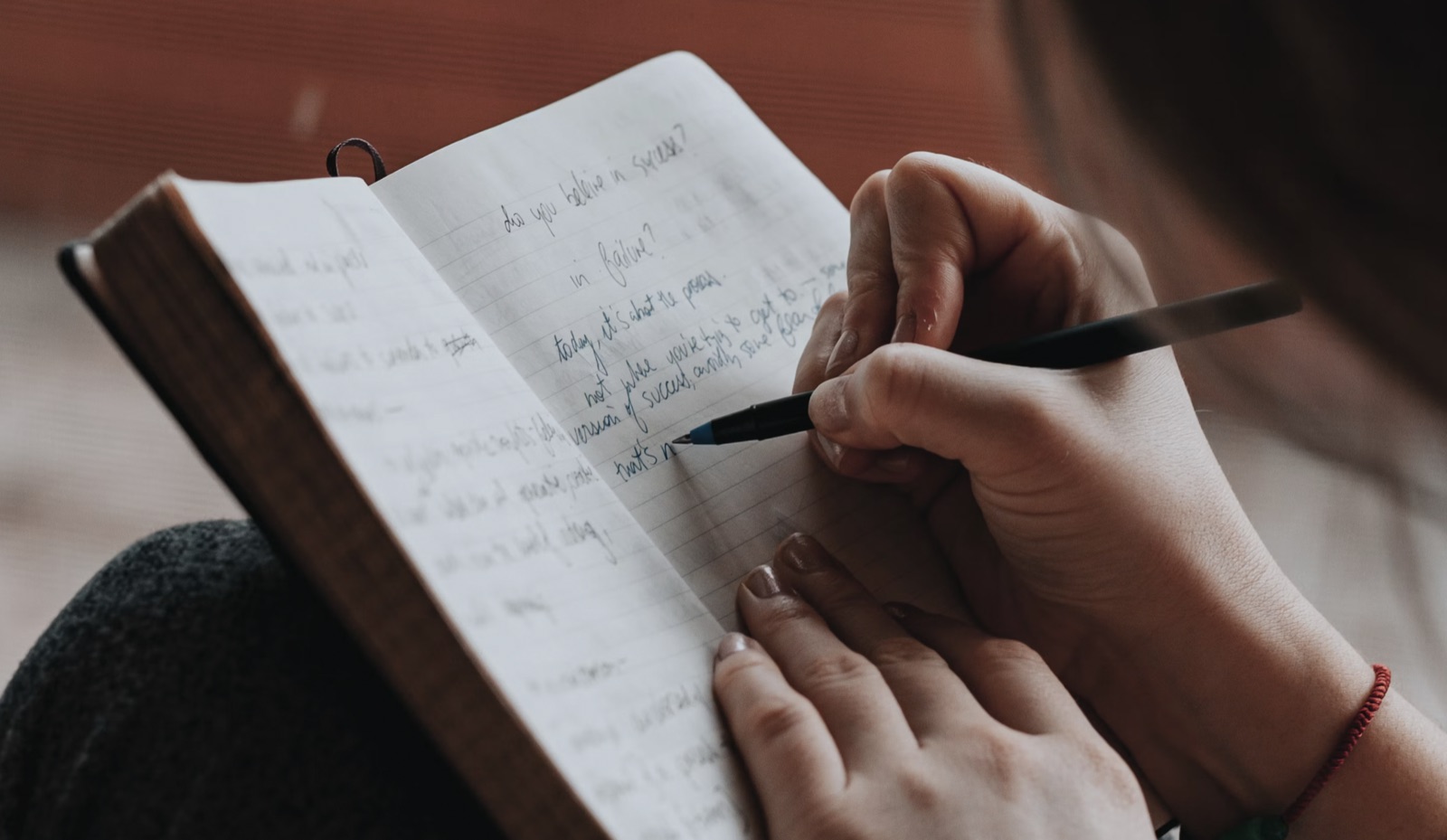 A woman reads tarot notes and journals quietly in a reflective setting.