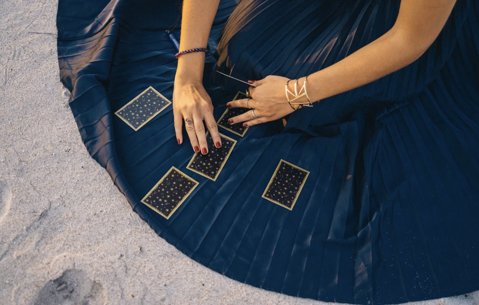 A tarot reader studying a spread and taking notes, emphasizing interpretation skill.