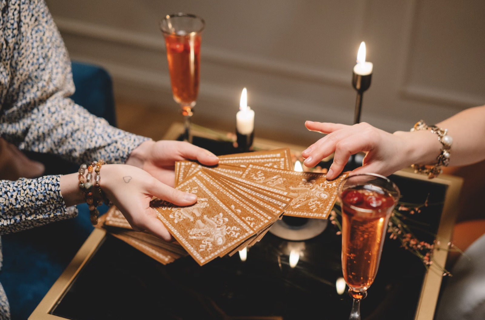Hands drawing tarot cards in a guided process
