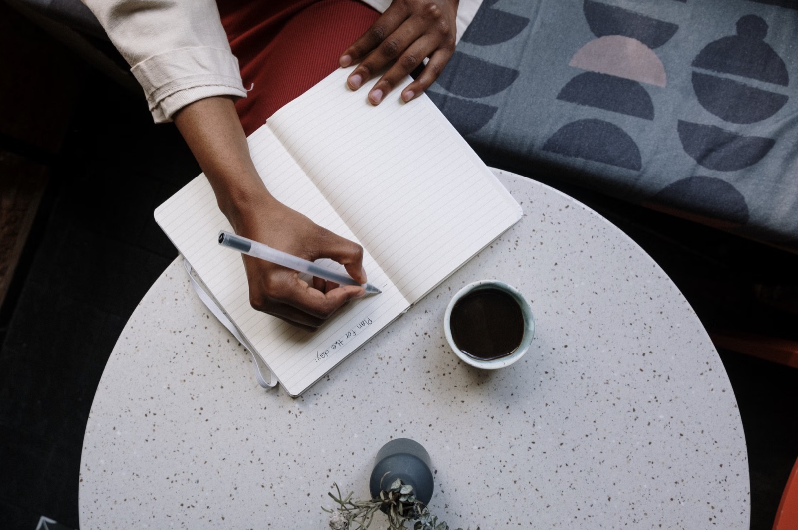 A close-up of writing in a notebook with a coffee cup nearby, representing a practical next step.