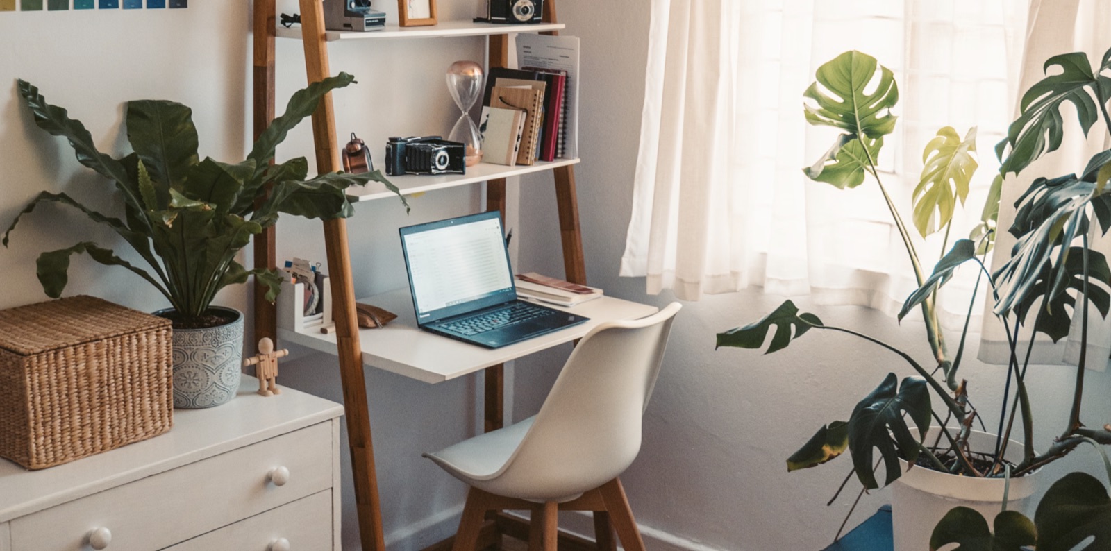 A grounded workspace with a laptop, notebook, and desk items in natural light.