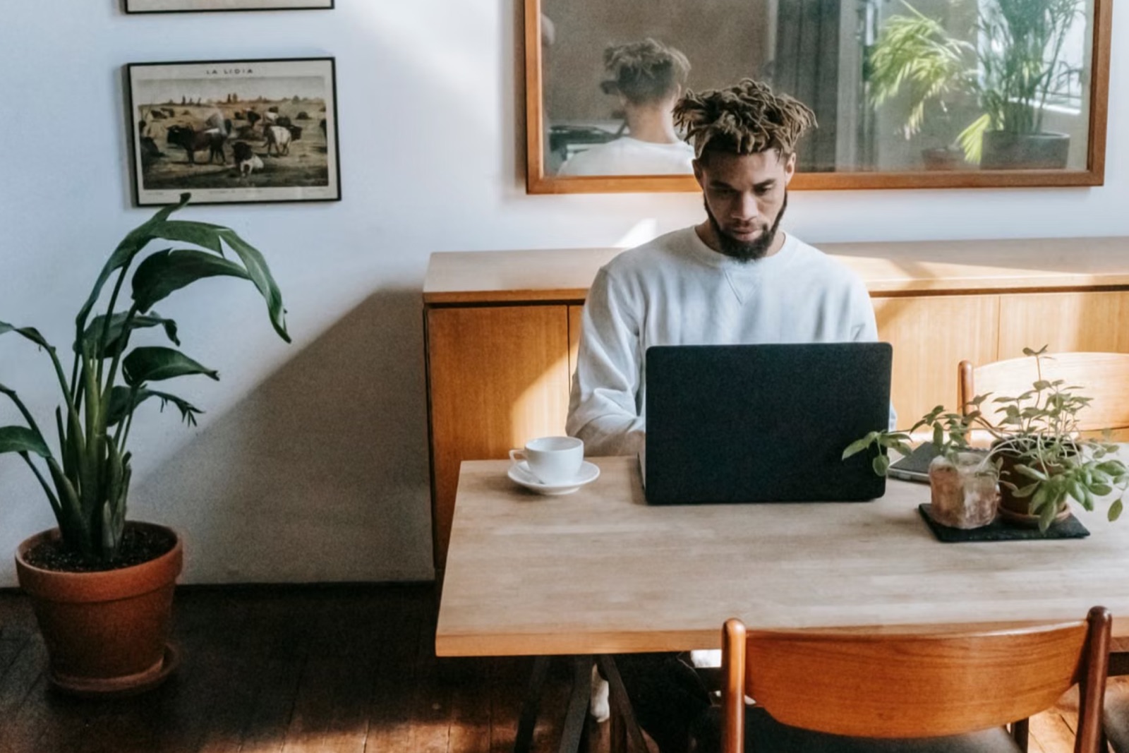 A bright workspace with a person working on a laptop and making visible progress.