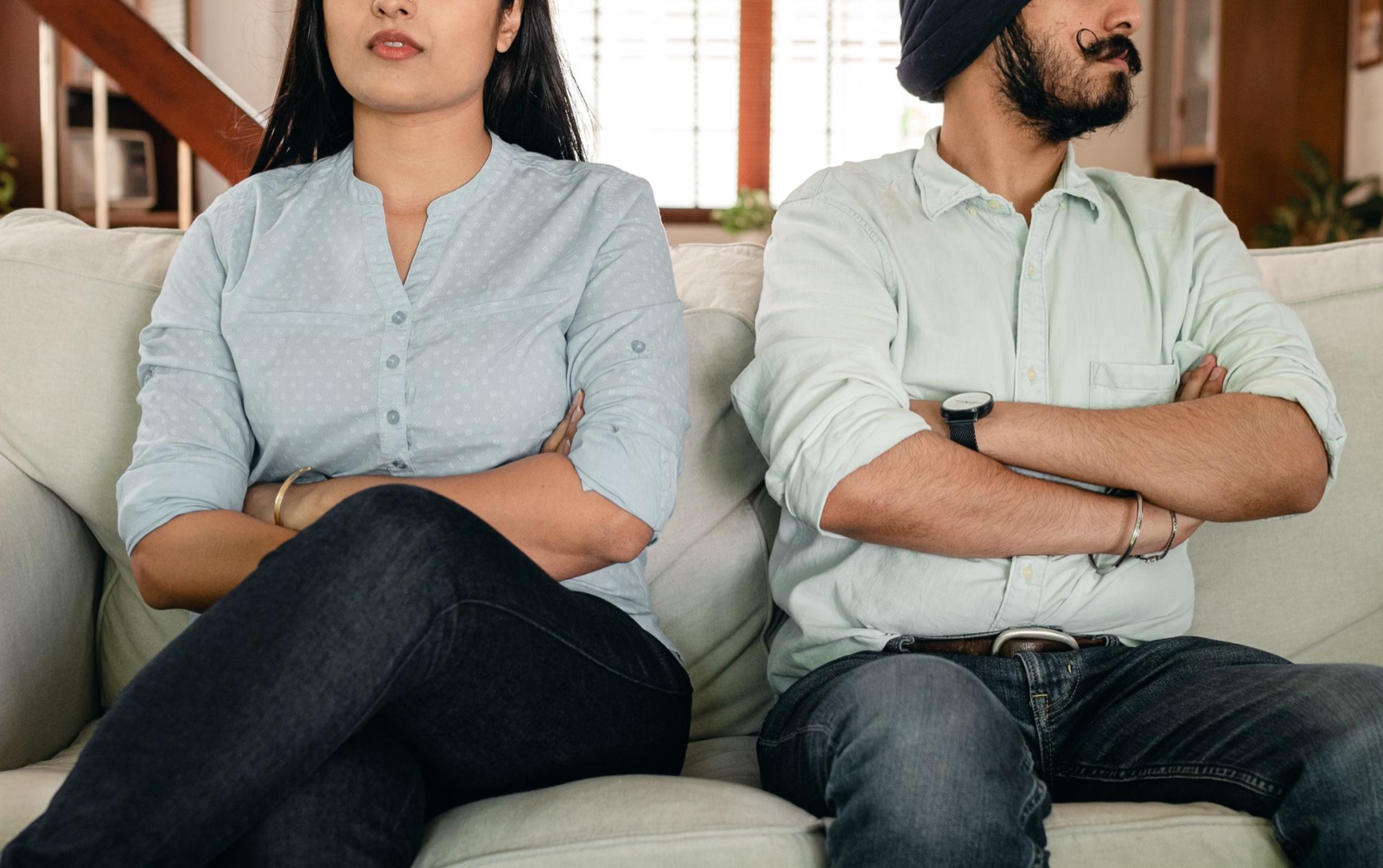 A couple sitting apart in silence, showing emotional distance.