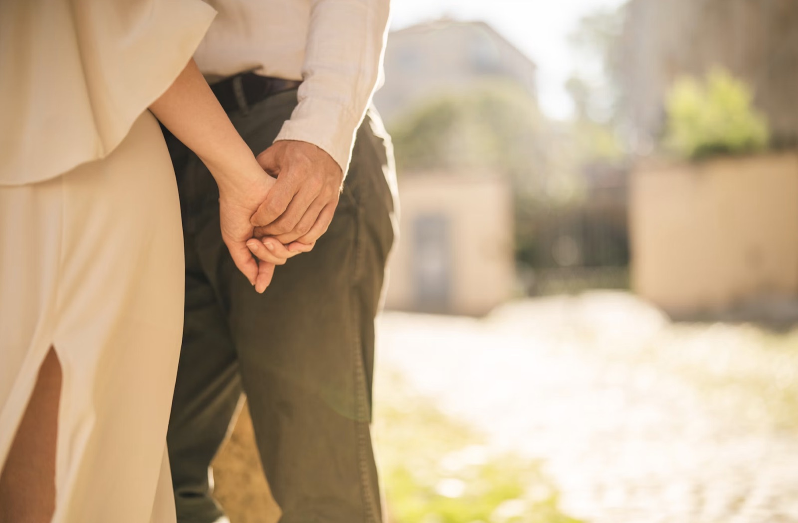 A couple holding hands in warm natural light.