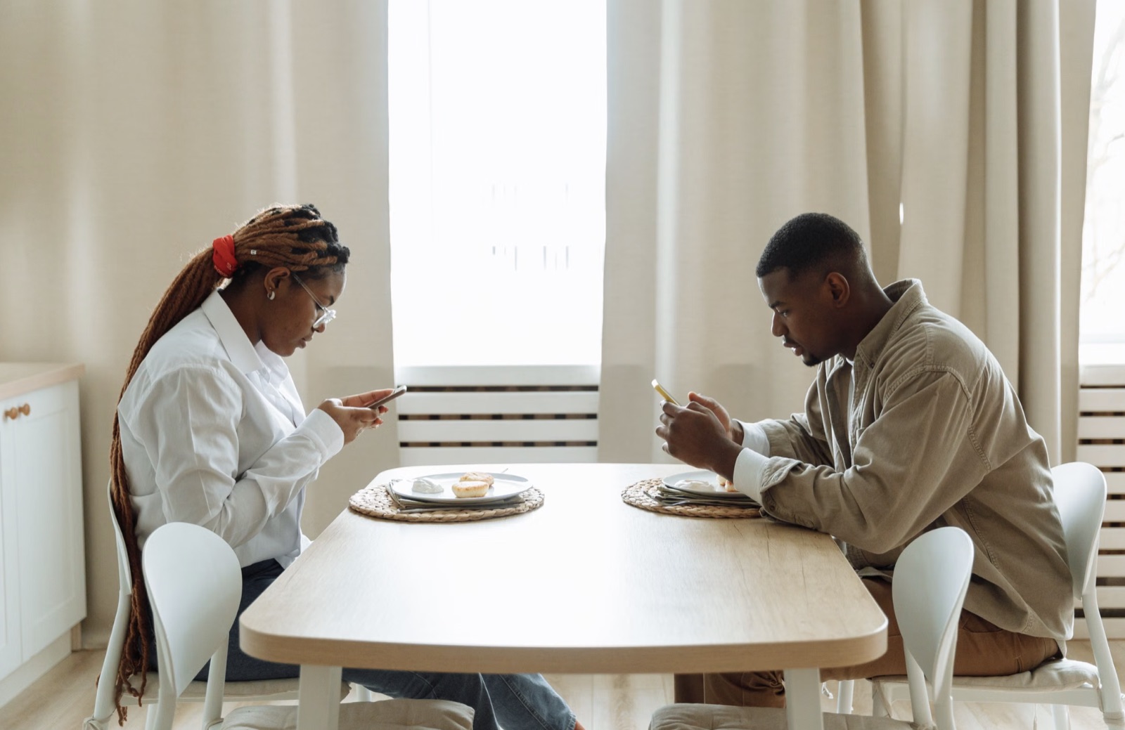 A distant couple sitting apart on a sofa in silence.