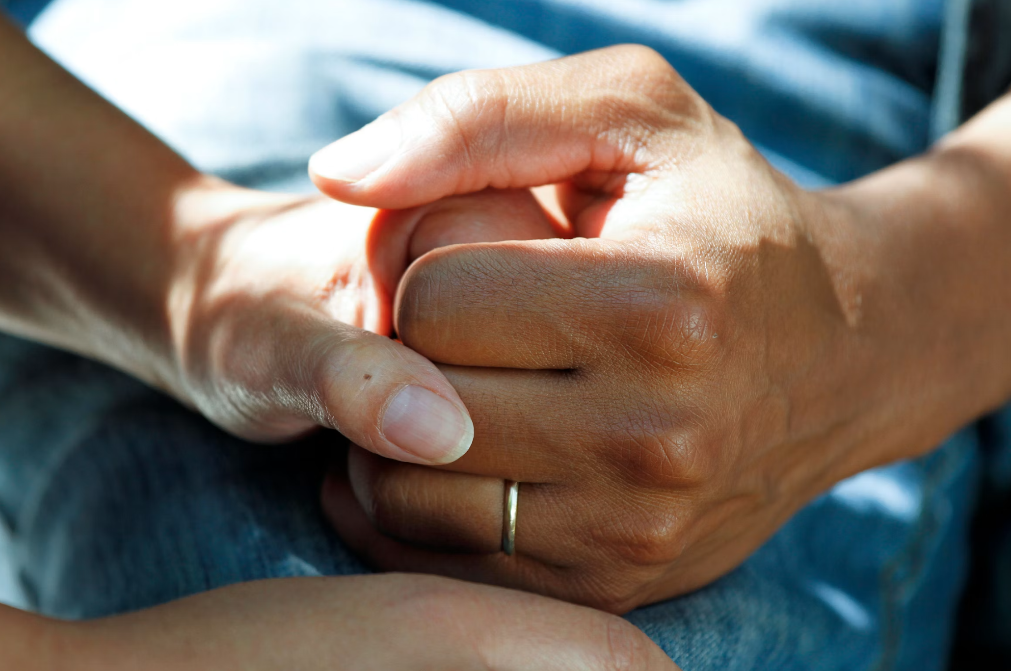 Two hands holding each other in a quiet moment of support.