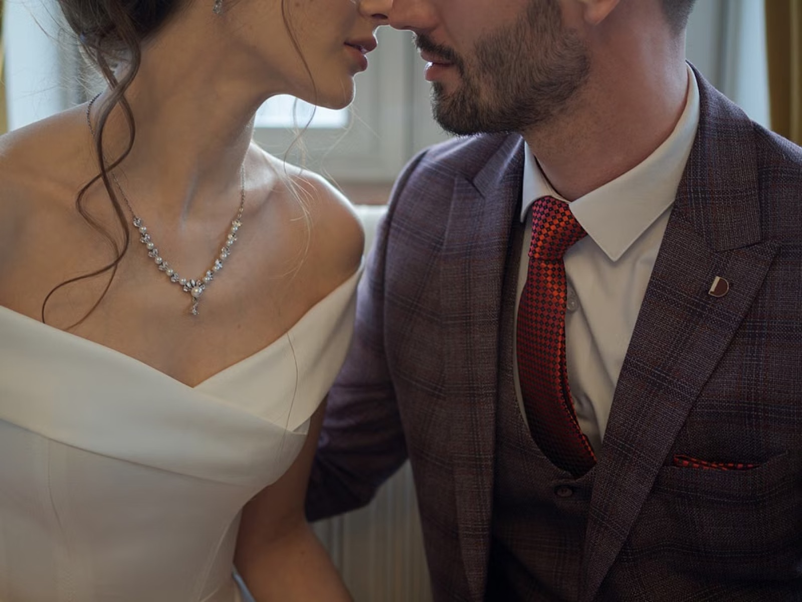 A dressed-up couple sitting very close in public, suggesting attraction and image, but also emotional tension and distance beneath the surface.