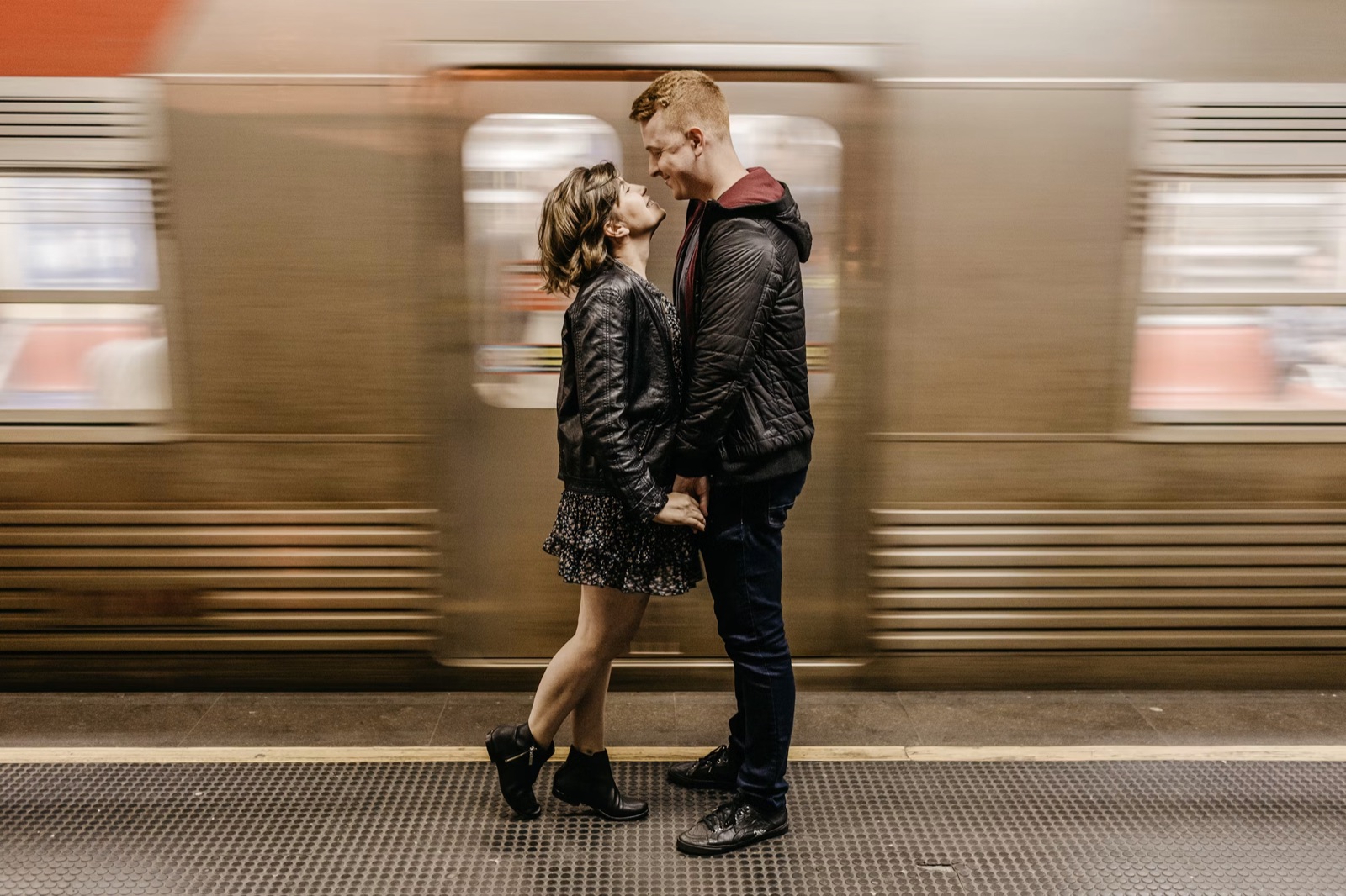 Two people embracing at a train station, symbolizing reunion and reconciliation.
