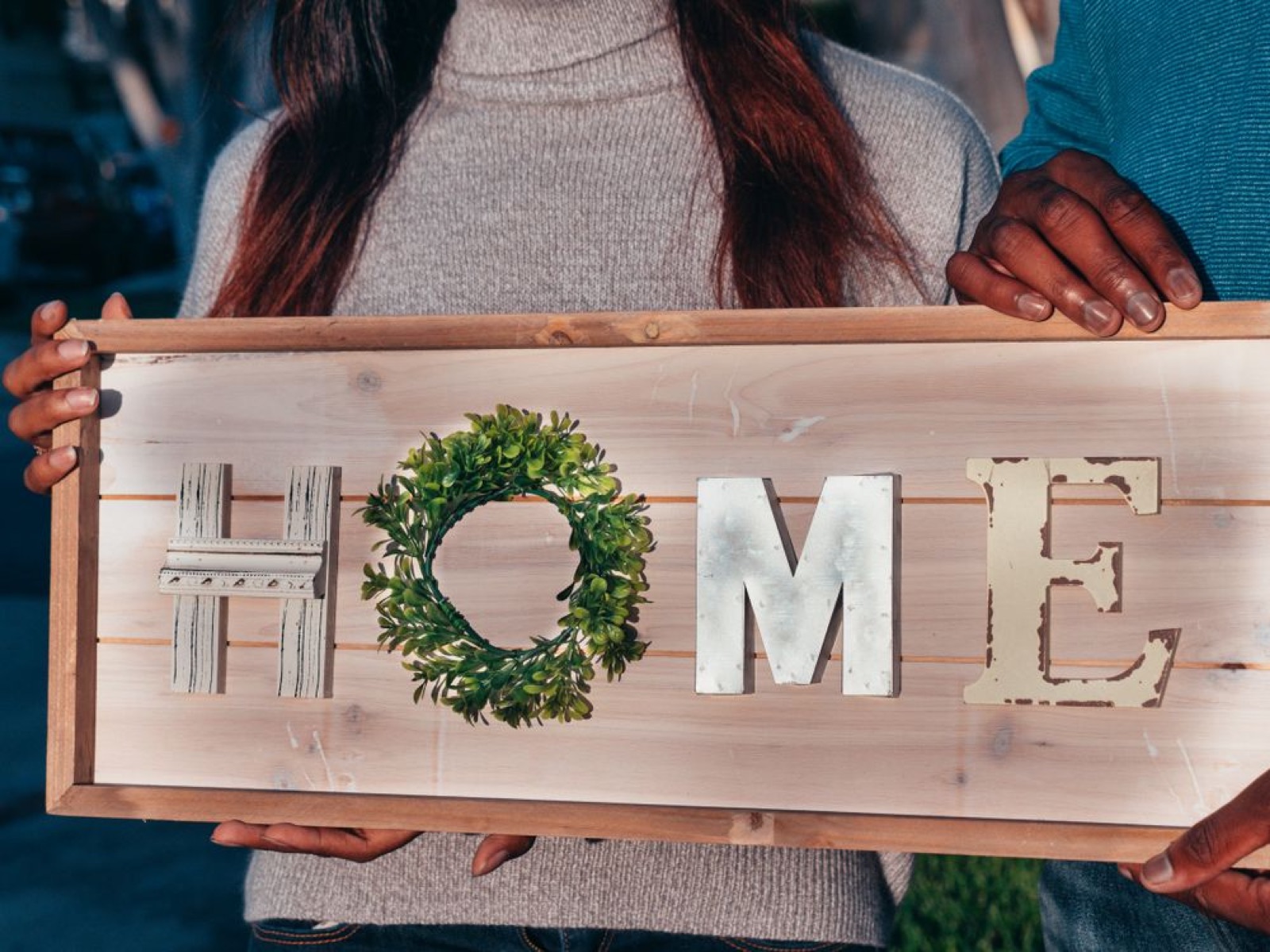A couple or family standing at the threshold of a home, symbolizing belonging and stable milestones.