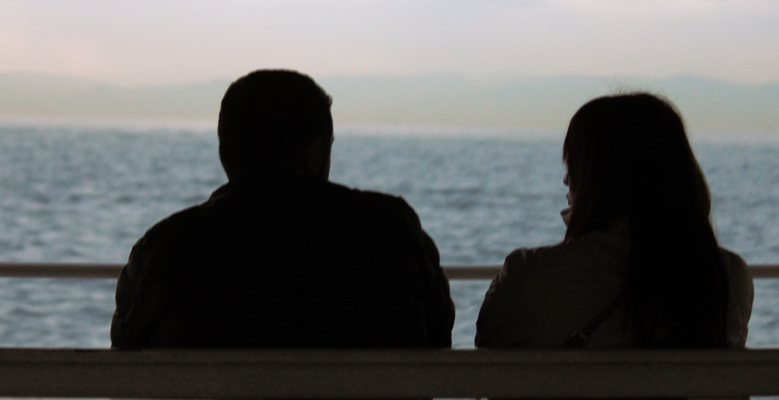 Two people standing apart outdoors, symbolizing emotional distance and relationship detachment.