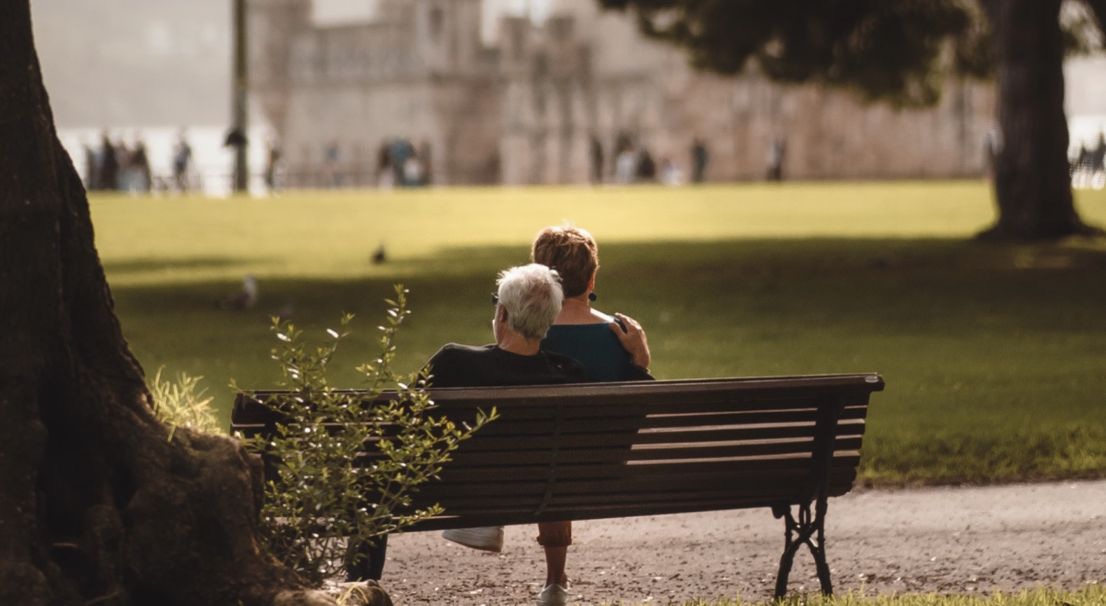 A couple sitting together on a park bench, sharing a calm moment outdoors.