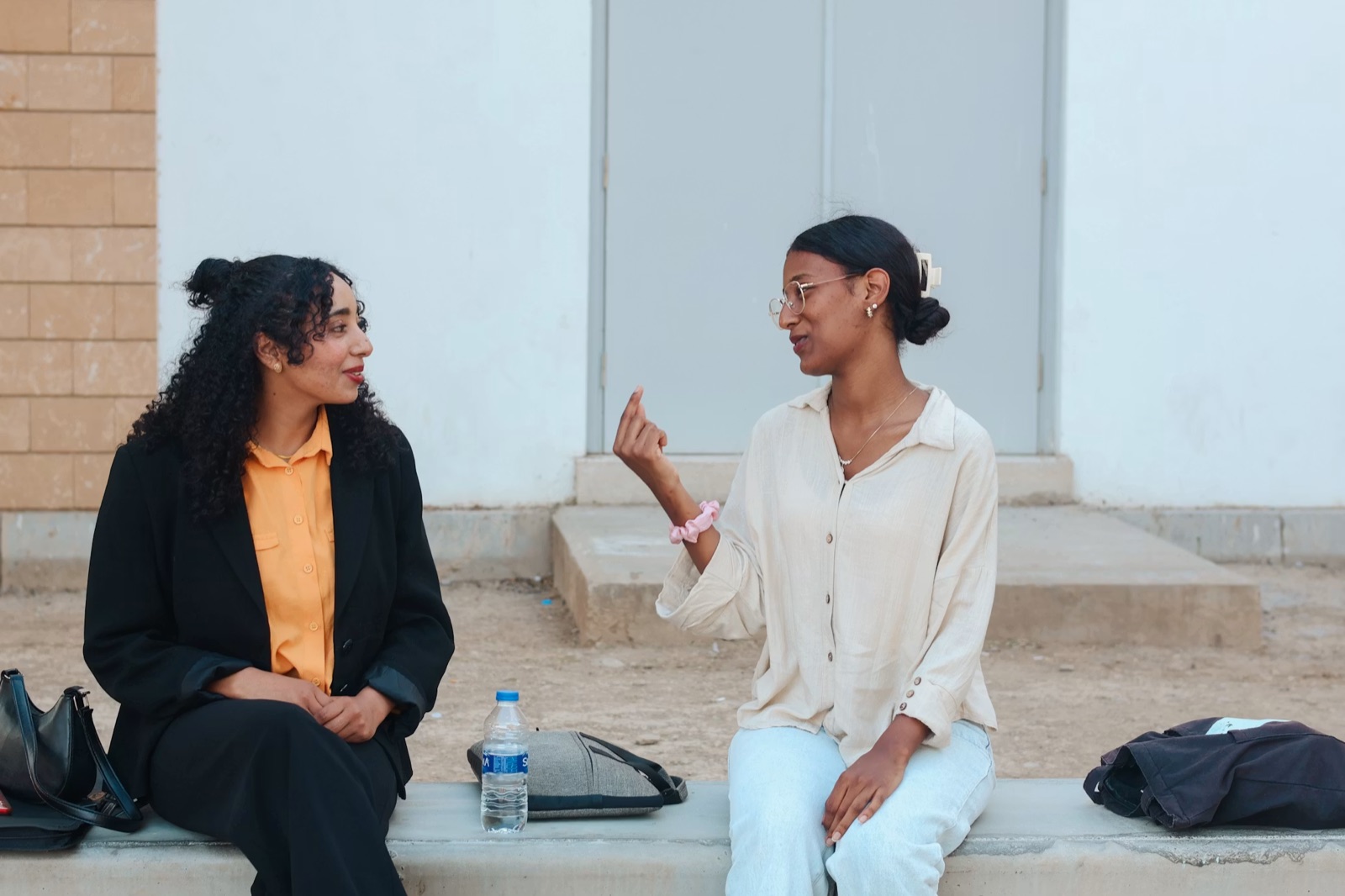 Two friends talking outdoors, relaxed and present.