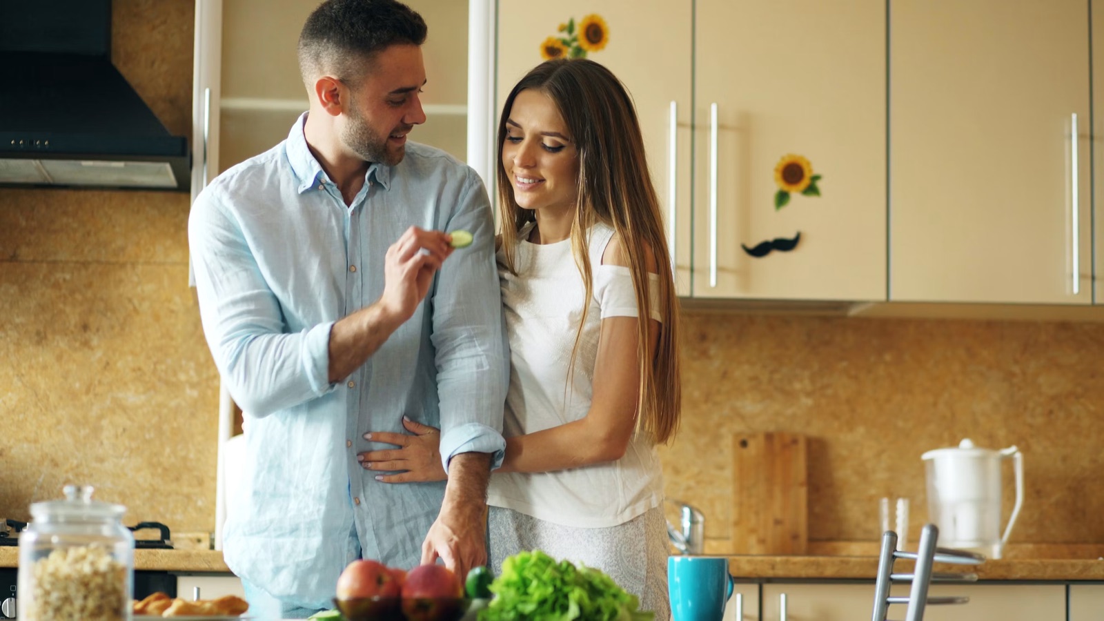 A couple cooking together in a bright kitchen, showing practical everyday intimacy.