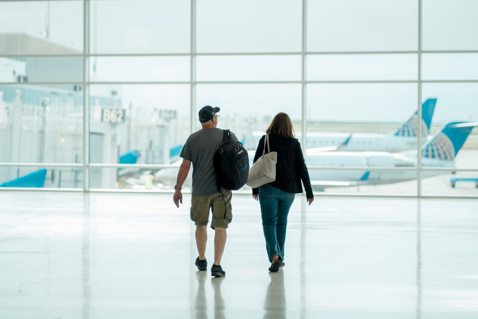 A couple moving through a travel setting together, reflecting distance, timing, and the need for a shared plan in love.