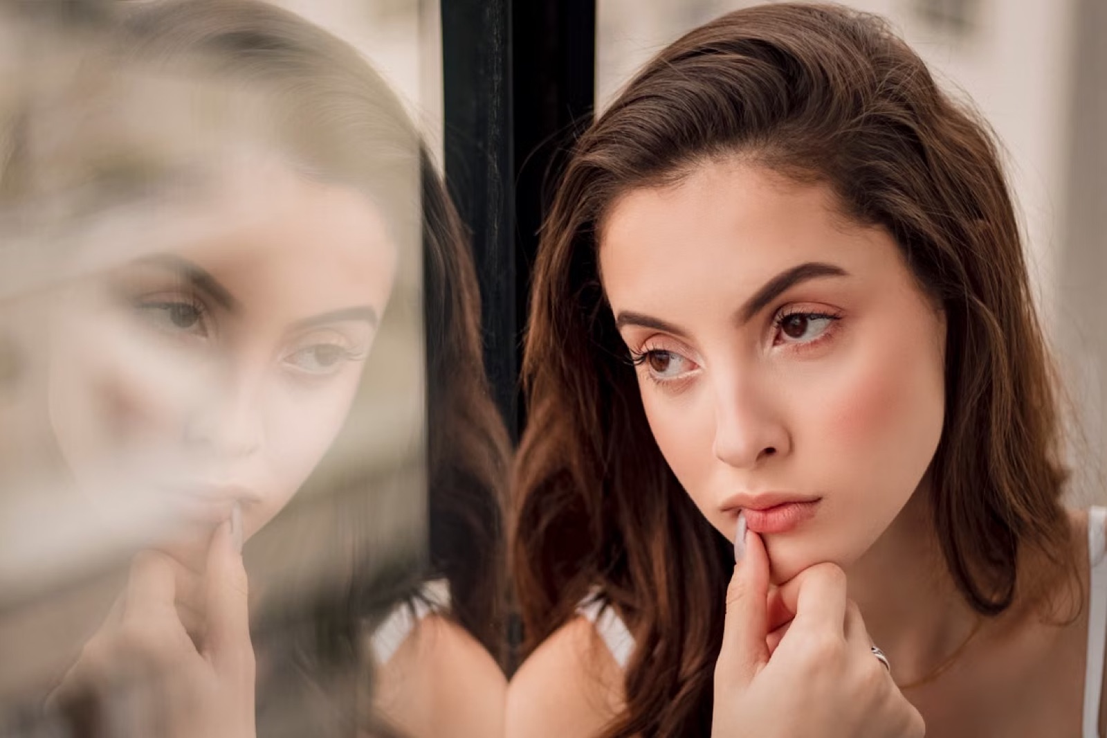 A reflective figure by a window, capturing emotional distance and the feeling that something is missing.