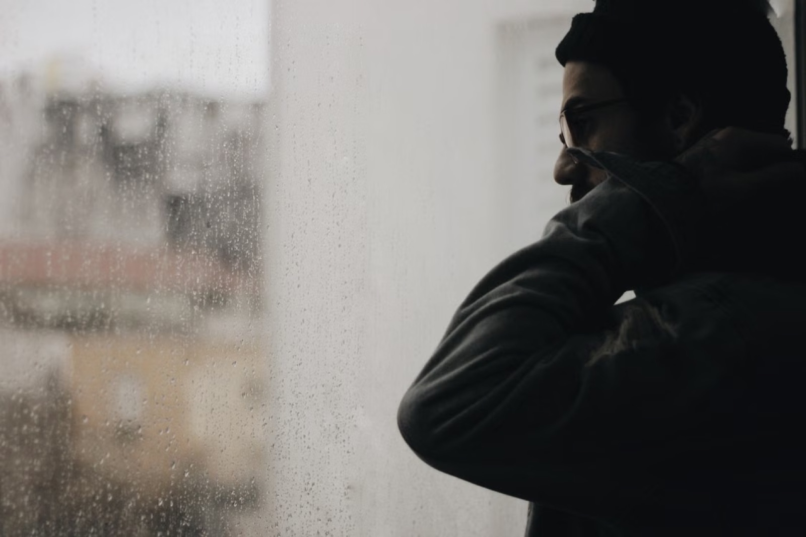 雨天窗边沉默的画面，表达断联中的自我保护、压抑与反复思考。