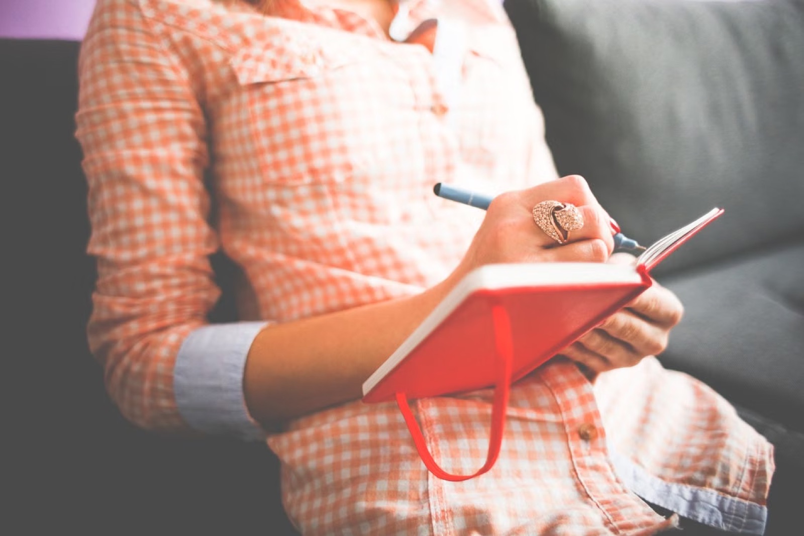A notebook and warm drink on a table while someone writes down a personal question