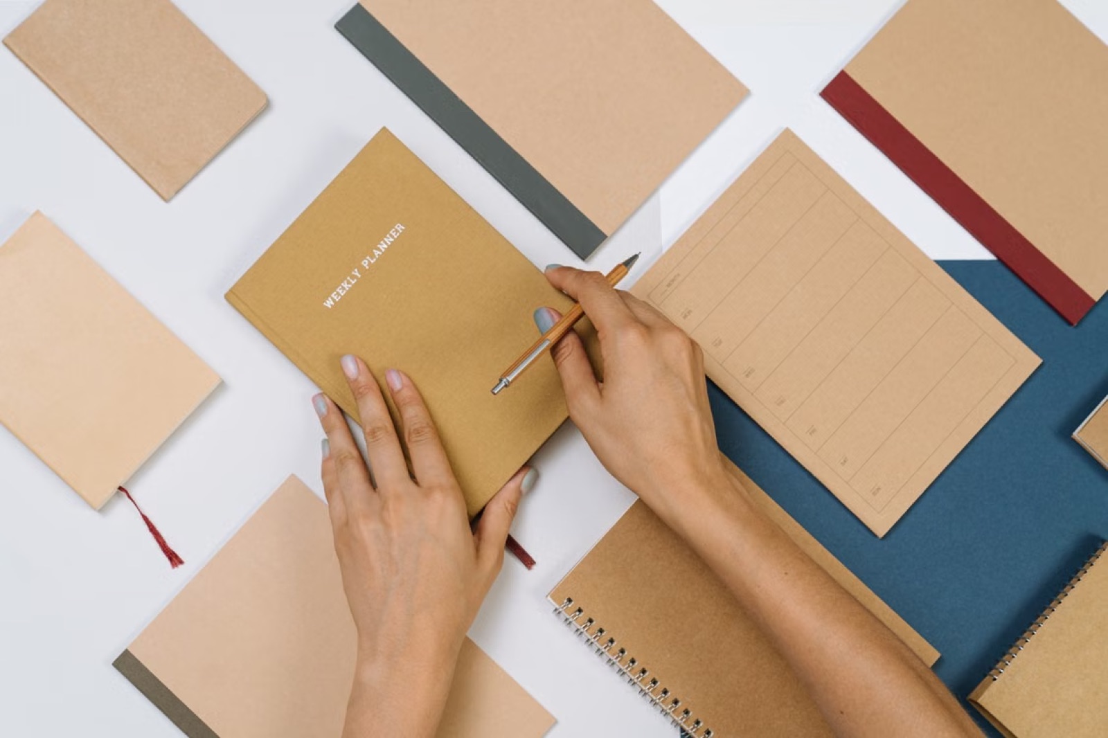 A hand writing goals in a notebook in soft window light