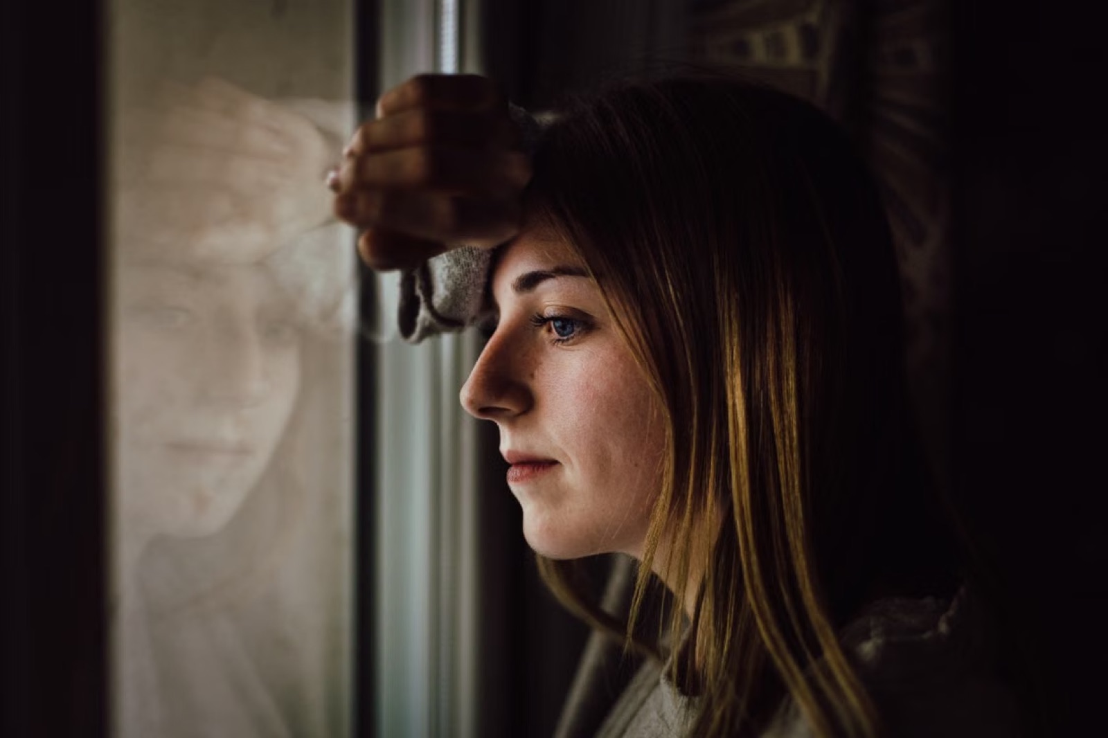 A thoughtful portrait of a person by a window, suggesting reflection and a shift in perspective