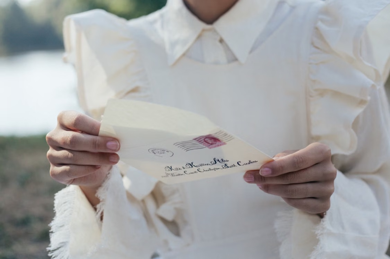 Hands exchanging a gentle note or small message, representing Page of Cups communication.