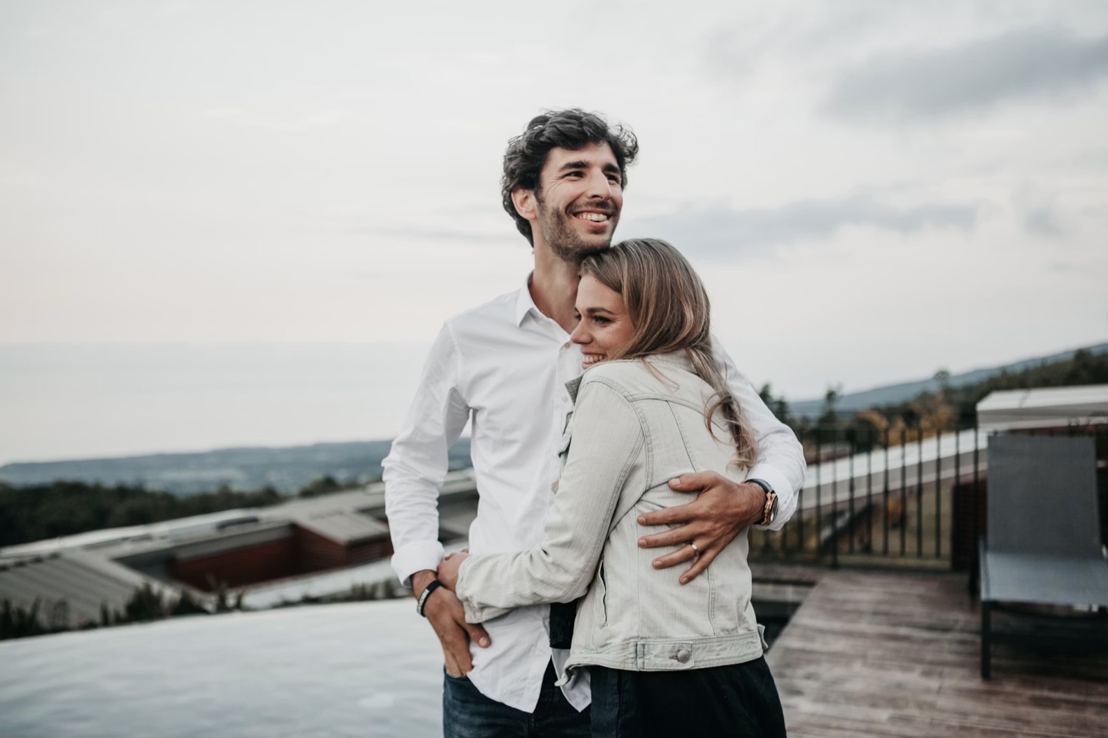 Two people in a warm, quiet setting holding hands, embracing, or looking at each other with a sense of promise rising—but without staged wedding imagery.