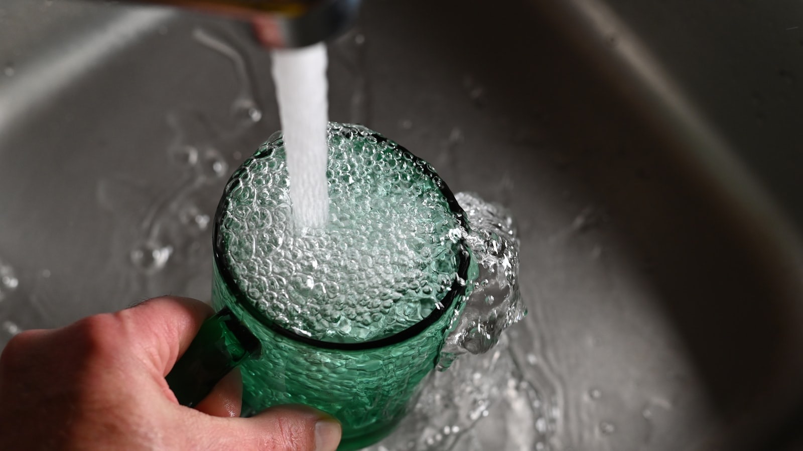 A cup of water overflowing, soft light, conveying an open heart beginning to flow.