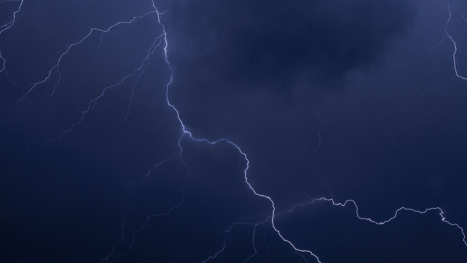 A lightning bolt tearing through a stormy night sky