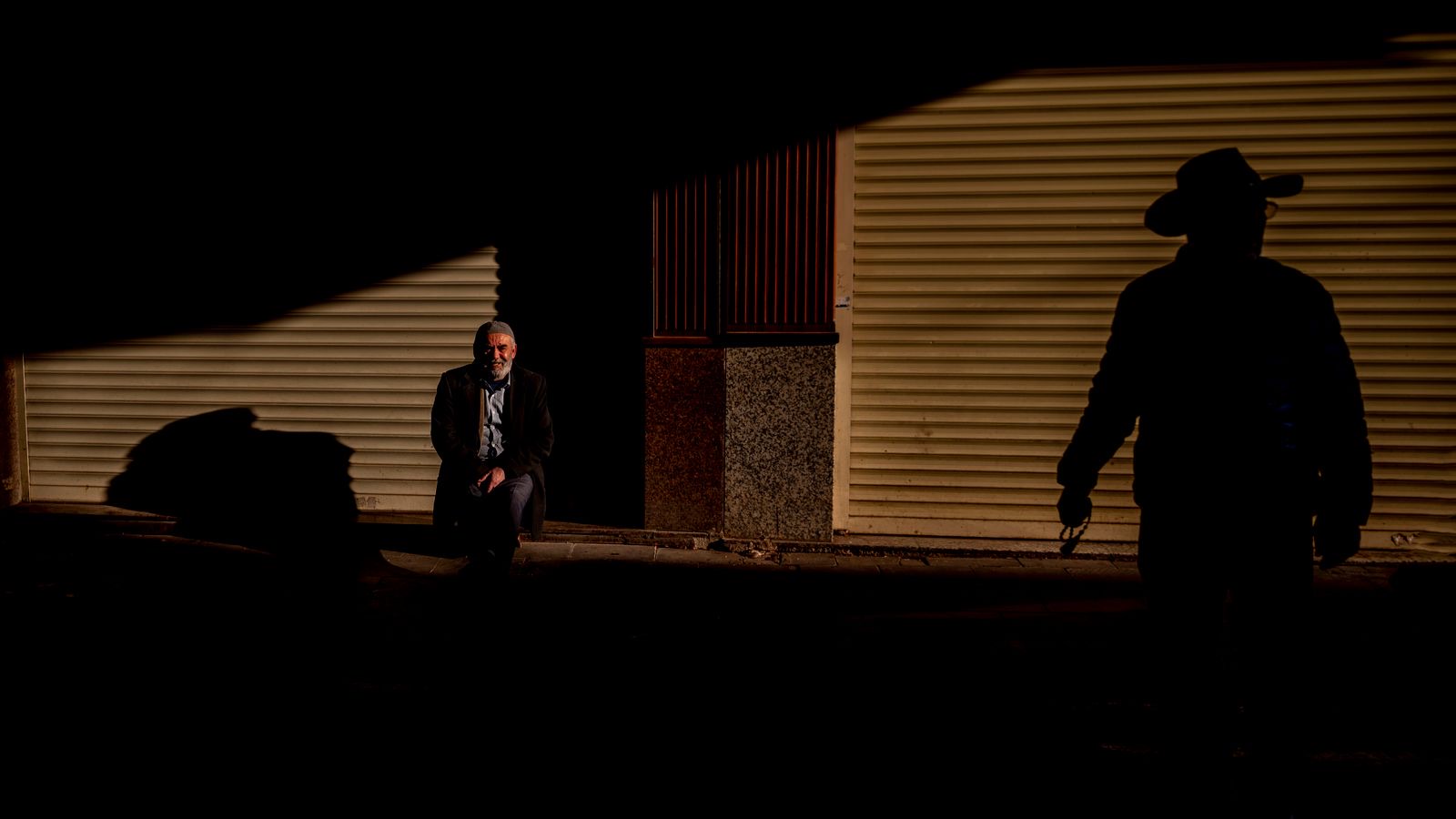 A lone silhouette under a bright spotlight