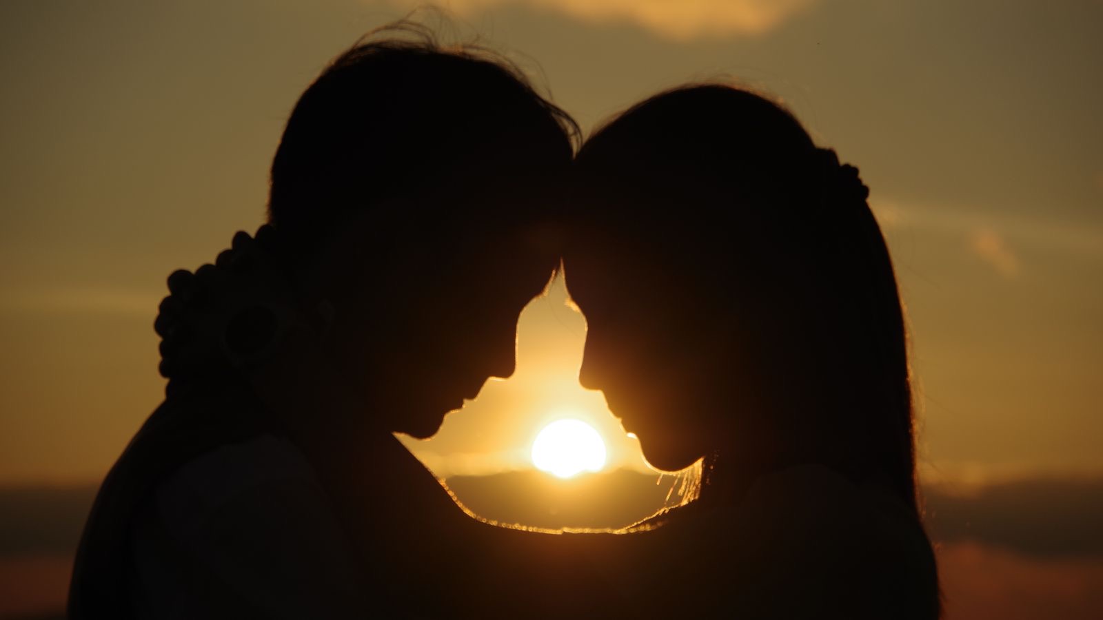 A happy couple looking at each other at sunset